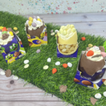 Four Chocolate Easter Egg Shell filled with cheesecake mixture decorated with double cream, chocolate buttons and Easter chocolates.