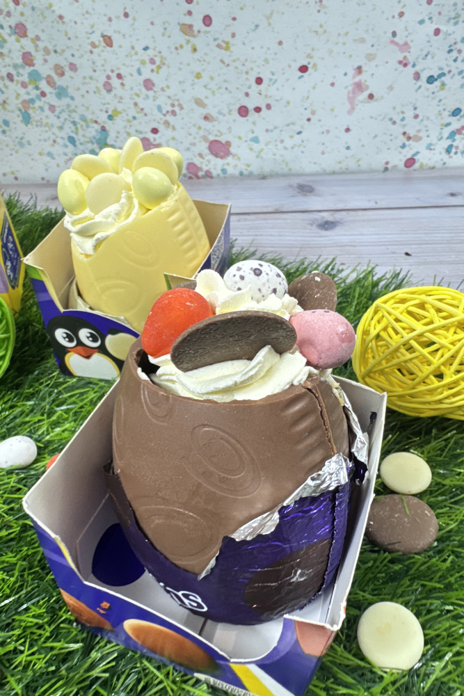 Chocolate Easter Egg Shell filled with cheesecake mixture decorated with double cream, chocolate buttons and Easter chocolates.